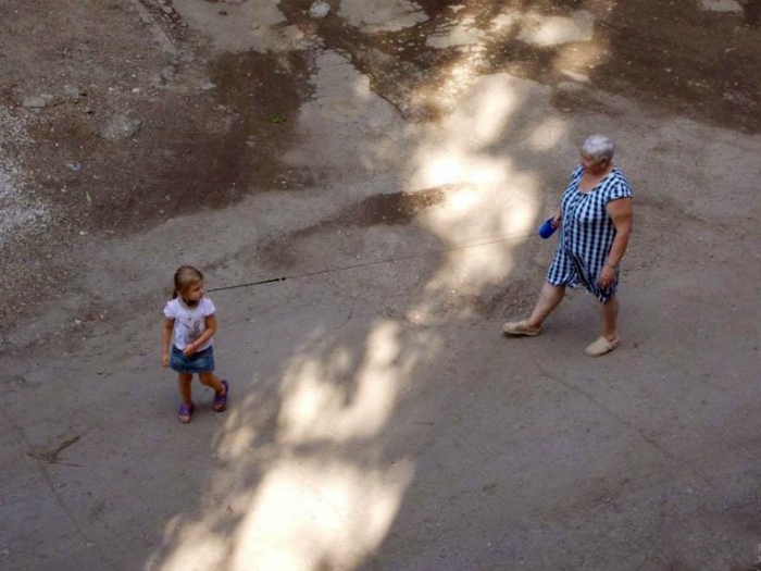 Заботливая бабушка выгуливает внучку на поводке, чтоб не убежала